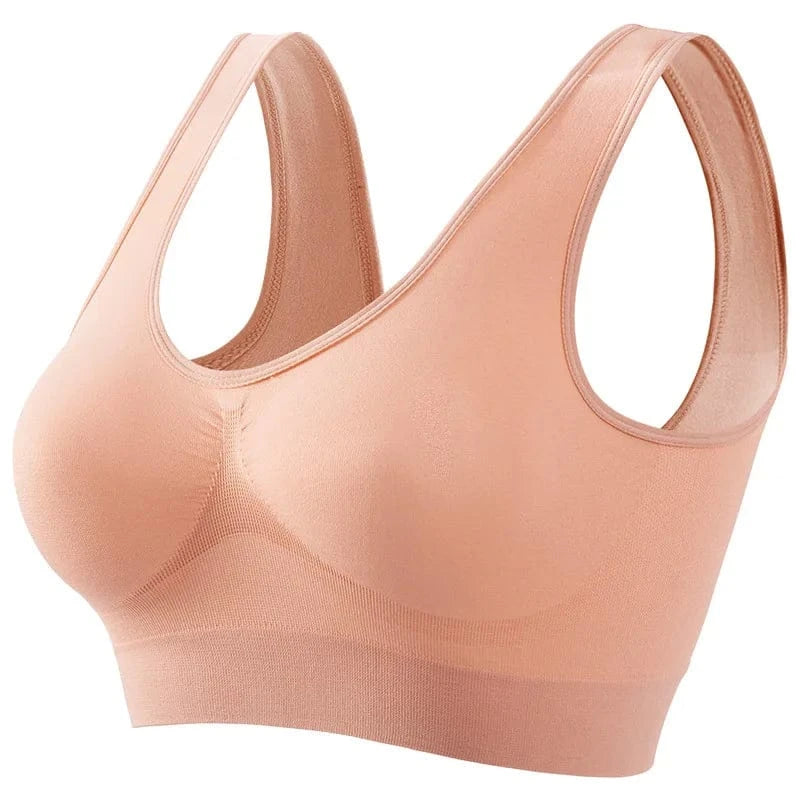 A nude-colored seamless sports bra with wide shoulder straps and a rounded neckline on a plain white background.