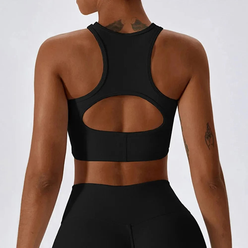 A black racerback sports bra with a circular cutout detail on the back worn by a person.